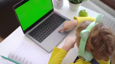 Close up Schoolboy child hands typing keyboard using touchscreen laptop online educational lesson course at home. Distance learning course remote video conference. Schoolgirl study does school