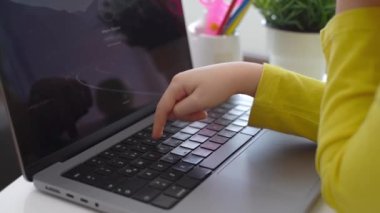 Klavye bilgisayarında daktilo eden zeki, beyaz bir ilkokul çocuğu. Çevrimiçi öğretmenlik, dijital dersler, evde bilgisayar programlama. Sanal eğitim. Öğrenci kız ders çalışıyor.