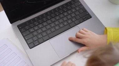 Close up Schoolboy child hands typing keyboard using touchscreen laptop online educational lesson course at home. Distance learning course remote video conference. Schoolgirl study does school