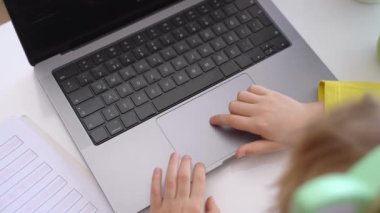 Close up Schoolboy child hands typing keyboard using touchscreen laptop online educational lesson course at home. Distance learning course remote video conference. Schoolgirl study does school