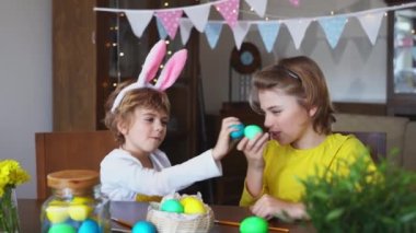Easter Sunday Family holiday traditions. Two caucasian happy siblings kids with bunny ears fighting with multi-colored Easter painted eggs. Having fun together