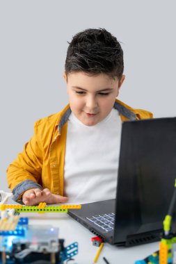 Robot lego programlama sınıfı. Çocuklar robot lego yapıp kodluyorlar. İnşaat blokları, dizüstü bilgisayar ve uzaktan kumandalı joystick kullanarak STEM eğitimi. Okul çocukları için teknolojik eğitim gelişimi