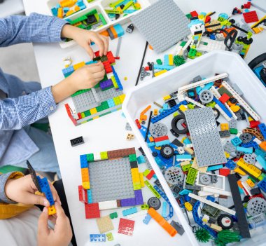 Robot lego programlama sınıfı. Çocuklar robot lego yapıp kodluyorlar. İnşaat blokları, dizüstü bilgisayar ve uzaktan kumandalı joystick kullanarak STEM eğitimi. Okul çocukları için teknolojik eğitim gelişimi