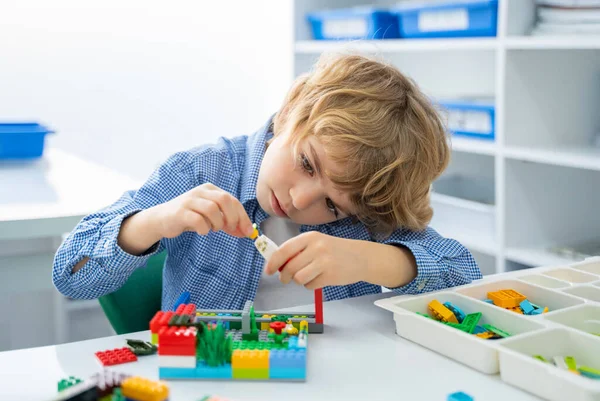 Robot lego programlama sınıfı. Çocuklar robot lego yapıp kodluyorlar. İnşaat blokları, dizüstü bilgisayar ve uzaktan kumandalı joystick kullanarak STEM eğitimi. Okul çocukları için teknolojik eğitim gelişimi