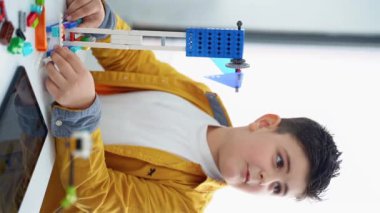 Robot programlama dersi. Çocuklar robot yapıp kodluyorlar. İnşaat blokları, dizüstü bilgisayar tableti, uzaktan kumandalı joystick kullanarak STEM eğitimi. Okul çocukları için teknolojik eğitim gelişimi