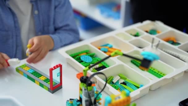 ロボットプログラミングクラス 子供はロボットを構築してコードします コンストラクタブロックとラップトップタブレット リモートコントロールジョイスティックを使用したStem教育 学校の子供のための技術教育開発 — ストック動画