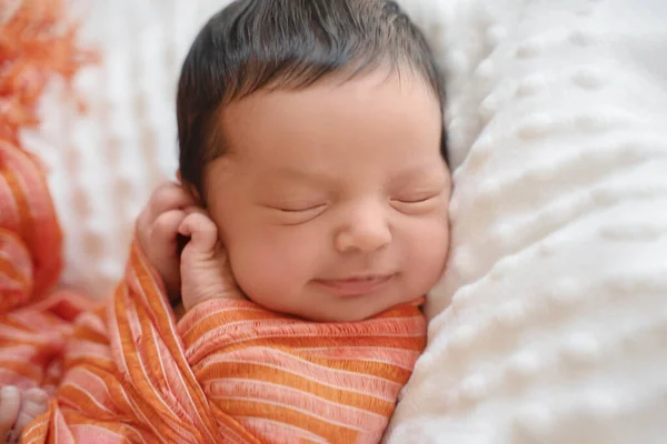 暗い髪の新生児が横に寝そべって笑っている 毛布の上でかわいい中東の子供 静かなシーンを閉じます — ストック写真