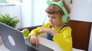 Kulaklıklı, video oyunu hobisi olan sevimli, zeki, beyaz, ilkokul çocuğu bilgisayar eğitimi veriyor. Dijital derste öğretmenlik, evde bilgisayar dersinde internet dersi. Sanal eğitim kursu