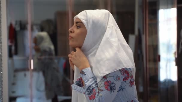 在家里更衣室里穿着头巾的中年穆斯林妇女的画像 看着镜子 头戴头巾的快乐女人的侧视脸 随和的伊斯兰女孩 — 图库视频影像