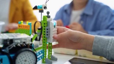 Robot programlama dersi. Çocuklar robot yapıp kodluyorlar. İnşaat blokları, dizüstü bilgisayar tableti, uzaktan kumandalı joystick kullanarak STEM eğitimi. Okul çocukları için teknolojik eğitim gelişimi