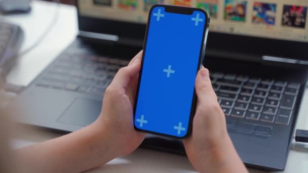 スマートフォンの緑の画面クロマキーを使用して10代の手を閉じます ノートパソコンアプリの背景をスクロールする子供オンラインエンターテイメント教育 オンラインショッピング ゲーム モバイルアプリ スマートフォンを使用して — ストック動画
