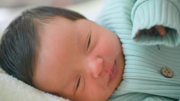 刚出生的婴儿 黑头发躺在旁边睡觉 睁开眼睛 拉着滑稽的脸 可爱的中东小孩躺在毛毯上 持续不断的场景逼近 — 图库视频影像
