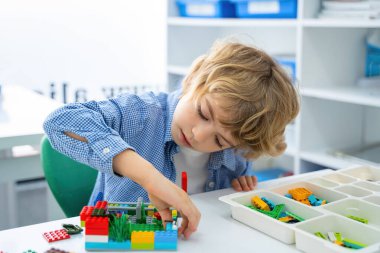 Robot programlama dersi. Çocuklar robot yapıp kodluyorlar. İnşaat blokları, dizüstü bilgisayar ve uzaktan kumandalı joystick kullanarak STEM eğitimi. Okul çocukları için teknolojik eğitim gelişimi