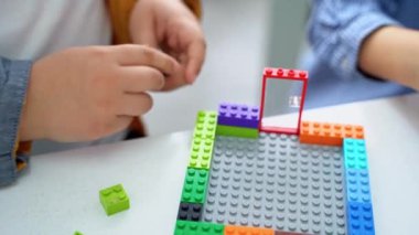 Robot programlama dersi. Çocuklar robot yapıp kodluyorlar. İnşaat blokları, dizüstü bilgisayar tableti, uzaktan kumandalı joystick kullanarak STEM eğitimi. Okul çocukları için teknolojik eğitim gelişimi