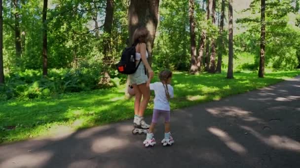 母と娘の女の子は夏の晴れた日に公園でローラーでインラインスケートを楽しむ 一緒に幸せな家族の時間 レジャースポーツ活動 — ストック動画