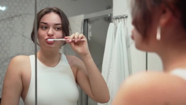 十几岁的女孩在家里的浴室里刷牙 牙科保健 卫生和健康的生活方式概念 早上口述晚上例行公事 自我照顾习惯年轻女子 — 图库视频影像