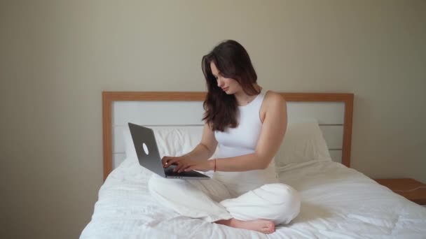 집에서 노트북을 사용하는 소녀가 침대에서 공부하고 기계로 타이핑하고 학습을 있습니다 — 비디오
