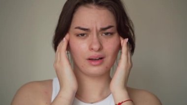 Sivilce iltihabından ve yüzünde sivilce izinden endişelenen genç bir kadın var. Genç kızda iltihaplı sivilce şişkinlik, kızarıklık ve bakteri, yağ ve derinden tıkanmış gözeneklerden oluşur.