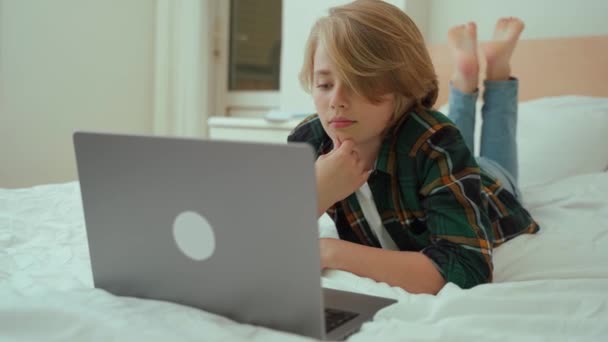 Genç Çocuk Dizüstü Bilgisayar Kullanıyor Yatakta Yatan Klavyede Yazan Çocuk — Stok video