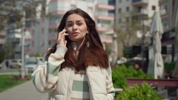 快乐的年轻女人在户外用手机说话 在城市背景下 快乐的少女用智能手机走路 社交媒体 暴民应用程序 观看视频 网上购物 — 图库视频影像