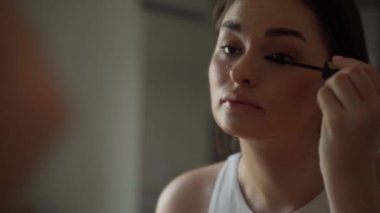 Kaşlarını fırçalayan güzel bir genç kadın. Genç İspanyol kadın makyaj kirpiklerini takıyor. Genç kızların jöle kaşları. Doğal güzellik, sivilce derisi ve doğal makyaj. Mükemmel kaş, dudaklar ve gür.