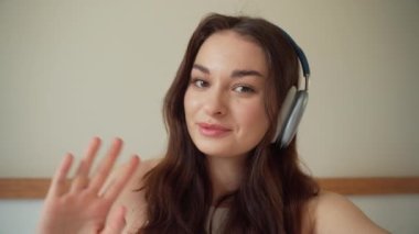 Arkadaşlarla görüntülü konuşma. Kulaklıklı genç bir kadın takım arkadaşlarıyla akıllı telefon konuşuyor. Genç bir kızın internet kamerasından görüntülü konuşma. Görüntülü konuşma.