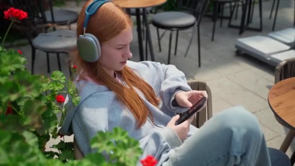 Εφηβική Κορίτσια Ακουστικά Δακτυλογράφησης Από Κινητό Καφέ Εξωτερικούς Χώρους Χαρούμενη — Αρχείο Βίντεο