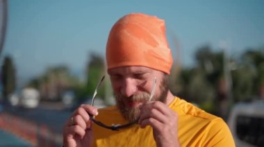 Spor giyimli sporcu, koşmadan önce güneş gözlüğü takıyor, güneşli bir sabah, dışarıda spor yapıyor, spor maratonu için motivasyon sağlıyor. Orta yaşlı yetişkinler için sağlıklı yaşam tarzı, kaybediyor