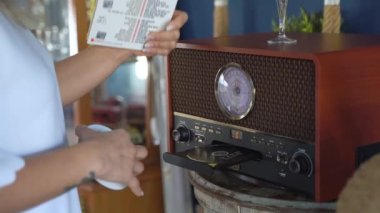 Yakın plan Kadın Müzik CD 'lerini Evde CD Çalarken Değiştiriyor. Rahatlama, Boş Zaman, Hobi, Günlük Yaşamda Müzik.