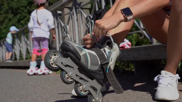 Close Mom Putting Inline Skates Rollers Preparing Child Public Park — Stock Video