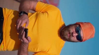 Spordan sonra koşan adam akıllı telefon kullanıyor. Dikey. Mafya uygulaması, takip cihazı, hız, kalp atışı. Sportif cep telefonu uygulamaları kullanarak idmandan sonra koşan yetişkin