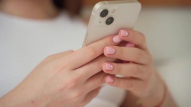 Akıllı telefon kullanan genç kadın elleri. Genç kız kayıyor, video makaraları izliyor, sohbet ediyor, sosyal medyada mesajlaşıyor, online alışveriş yapıyor. Günlük yaşamda teknoloji