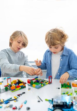 Robot programlama dersi. Çocuklar robot yapıp kodluyorlar. İnşaat blokları, dizüstü bilgisayar ve uzaktan kumandalı joystick kullanarak STEM eğitimi. Okul çocukları için teknolojik eğitim gelişimi