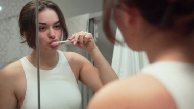 Evdeki banyoda dişlerini fırçalayan genç kız. Diş bakımı, hijyen ve sağlıklı yaşam tarzı konsepti. Oral sabah rutini, kişisel bakım alışkanlıkları genç kadın. 