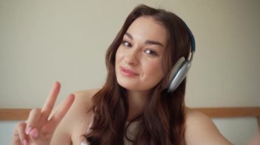 Arkadaşlarla görüntülü konuşma. Kulaklıklı genç bir kadın takım arkadaşlarıyla akıllı telefon konuşuyor. Genç bir kızın internet kamerasından görüntülü konuşma. Görüntülü konuşma.