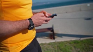 Spor faaliyetlerini yaptıktan sonra akıllı telefonu kullanarak koşan adamı kapat. Mafya uygulaması, takip cihazı, hız, kalp atışı. Sportif cep telefonu uygulamaları kullanarak idmandan sonra koşan yetişkin