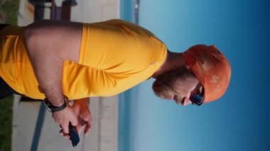 Spor faaliyetlerini yaptıktan sonra akıllı telefonu kullanarak koşan adamı kapat. Mafya uygulaması, takip cihazı, hız, kalp atışı. Sportif cep telefonu uygulamaları kullanarak idmandan sonra koşan yetişkin