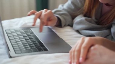 İki genç kız öğrenci ödevlerini evde laptopla, kompozisyon yazarak, proje yazarak, yakın çekim yaparak çalışıyor.