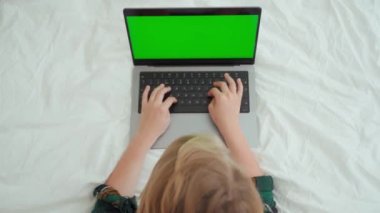 Laptop yeşil ekran Chroma Key kullanan Kafkas Ortaokulu öğrencisini kapatın. Klavyede yazan çocuk. Çevrimiçi öğretmenlik, dijital dersler, evde bilgisayar dersleri. Sanal eğitim