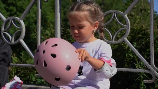 Kleine Ongelukkige Grillige Meisje Houden Beschermende Roze Helm Oneens Iets — Stockvideo