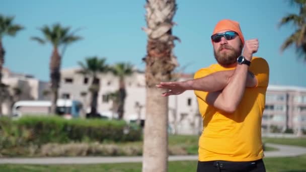 Bearded Man Sportkläder Värmer Muskler Och Leder Innan Löpning Solig — Stockvideo