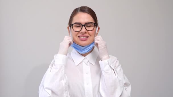 Schöne Gesunde Frau Trägt Medizinische Gesichtsmaske Auf Weißem Hintergrund Menschen — Stockvideo