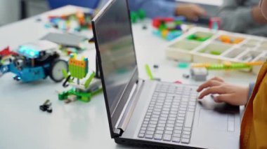 Robot programlama dersi. Çocuklar robot yapıp kodluyorlar. İnşaat blokları, dizüstü bilgisayar ve uzaktan kumandalı joystick kullanarak STEM eğitimi. Okul çocukları için teknolojik eğitim gelişimi