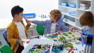 Robot programlama dersi. Çocuklar robot yapıp kodluyorlar. İnşaat blokları, dizüstü bilgisayar tableti, uzaktan kumandalı joystick kullanarak STEM eğitimi. Okul çocukları için teknolojik eğitim gelişimi