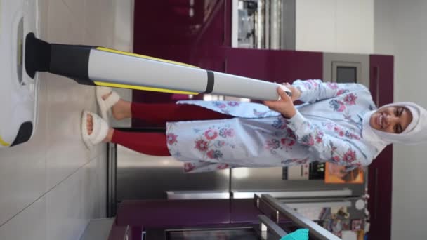 Muslimische Frau Mittleren Alters Staubsaugt Mit Drahtlosem Reinigungsboden Der Küche — Stockvideo