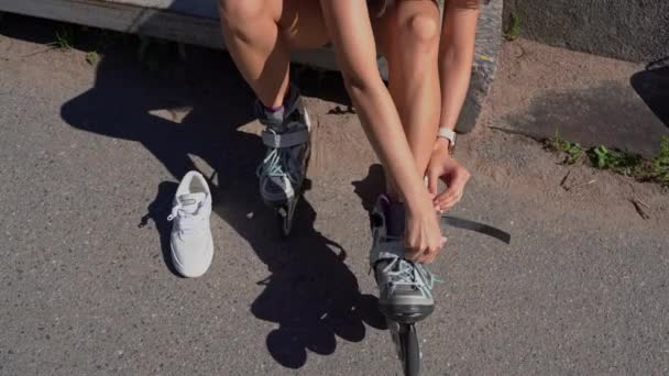 夏には公共公園でインラインスケートローラーを置くクローズアップ女の子 青少年レジャー屋外スポーツ活動ゲーム追求 健康的なライフスタイル トップ表示 — ストック動画