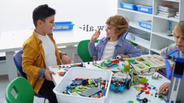 Robot programlama dersi. Çocuklar robot yapıp kodluyorlar. İnşaat blokları, dizüstü bilgisayar tableti, uzaktan kumandalı joystick kullanarak STEM eğitimi. Okul çocukları için teknolojik eğitim gelişimi