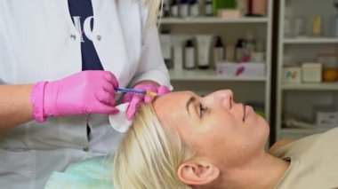 Kozmetik uzmanının elinde kozmetik enjeksiyonları için şırınga var. Deri turgor liposuction biyo-evitalizasyon mezoterapi güzellik prosedürlerini salondaki müşteriye kaldırıyor.
