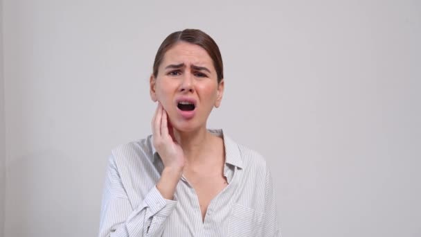 中年女性に苦しみます歯痛上の灰色の背景 — ストック動画