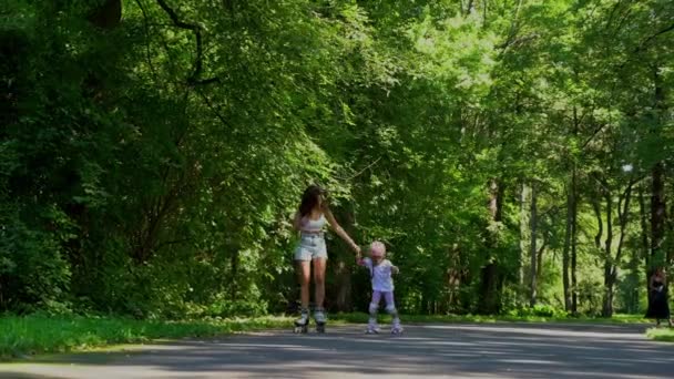 夏天阳光明媚的日子 妈妈在公园教小女孩用滚子在线滑冰 家庭团聚快乐 康体活动快乐 — 图库视频影像